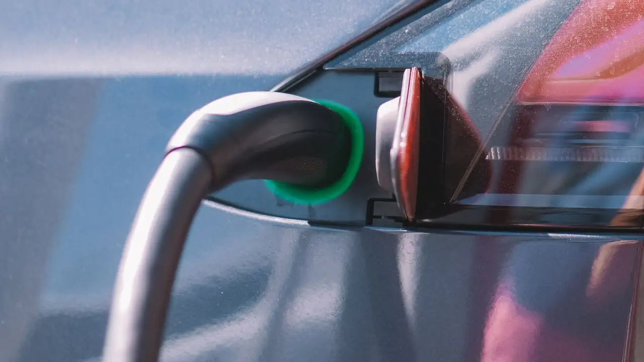 Ladekabel mit grün leuchtendem Anschluss an der Ladebuchse eines Elektroautos