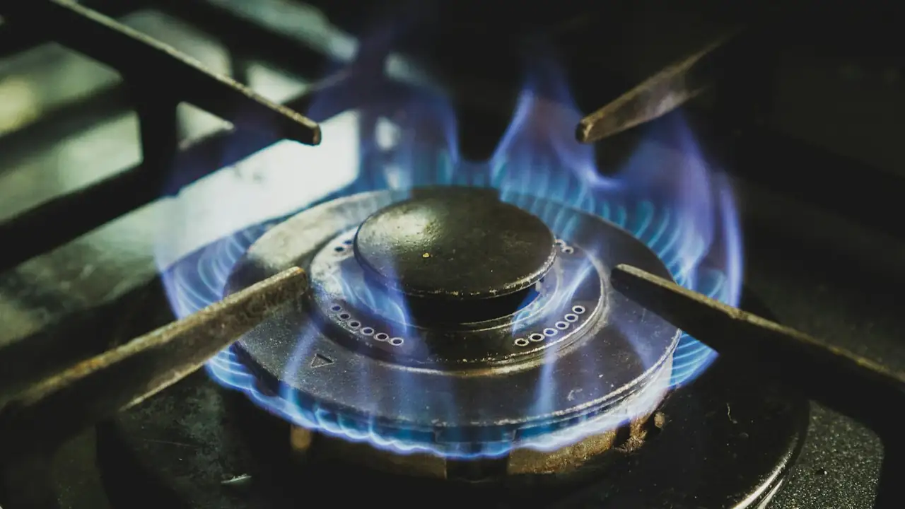 Blau brennende Gasflamme an einem Brenner eines Gasherds