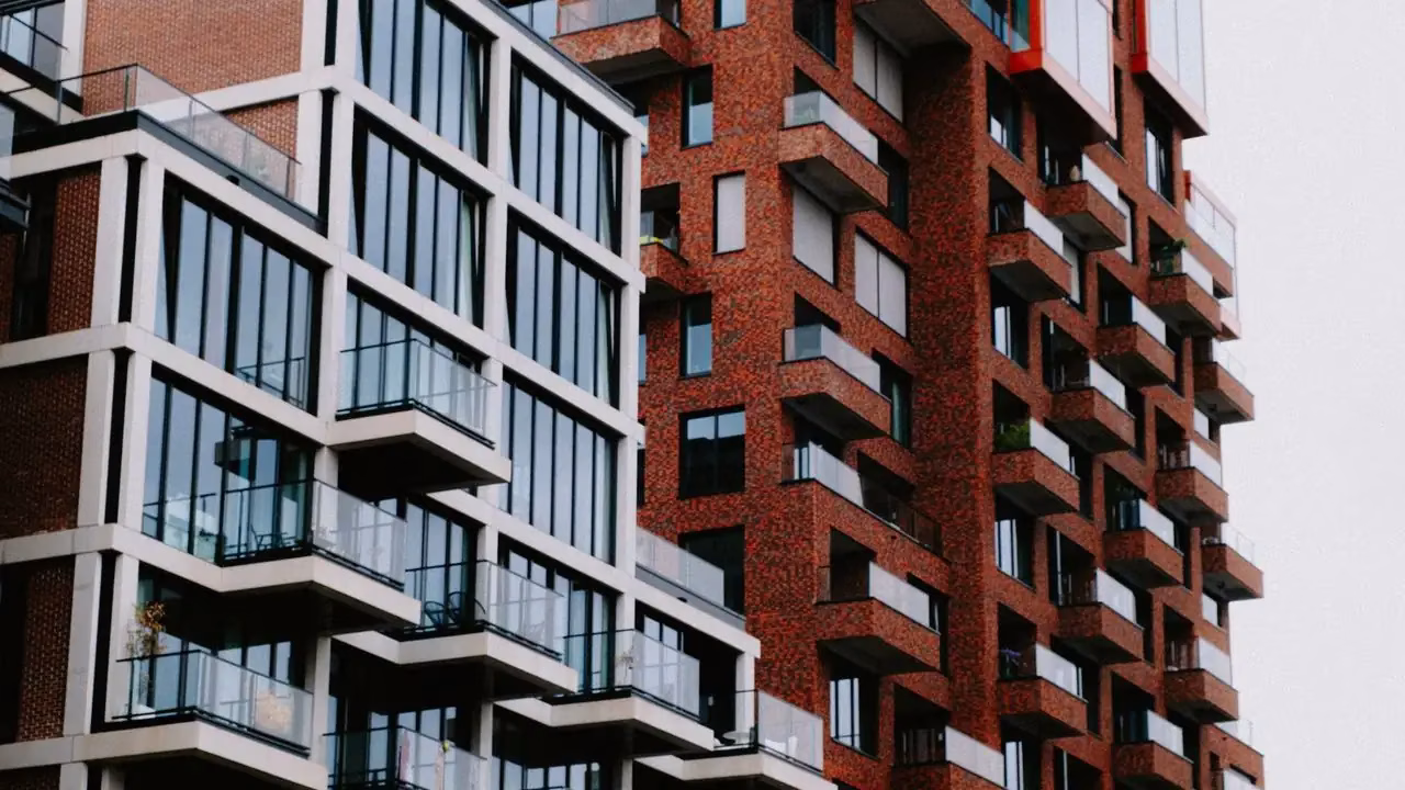 Neubau-Wohnhaus mit Glasfassade neben einem Backsteingebäude Neubau-Wohnhaus mit Glasfassade neben einem Backsteingebäude