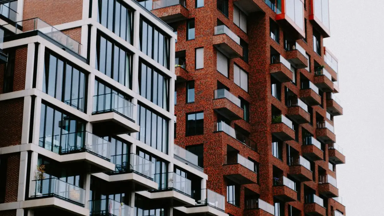 Neubau-Wohnhaus mit Glasfassade neben einem Backsteingebäude