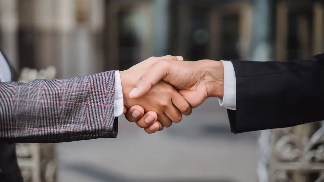 Handschlag zwischen zwei Geschäftsleuten in Anzugsjacken