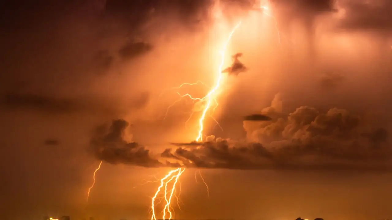 Blitz in einem orange gefärbten Gewitterhimmel mit dunklen Wolken