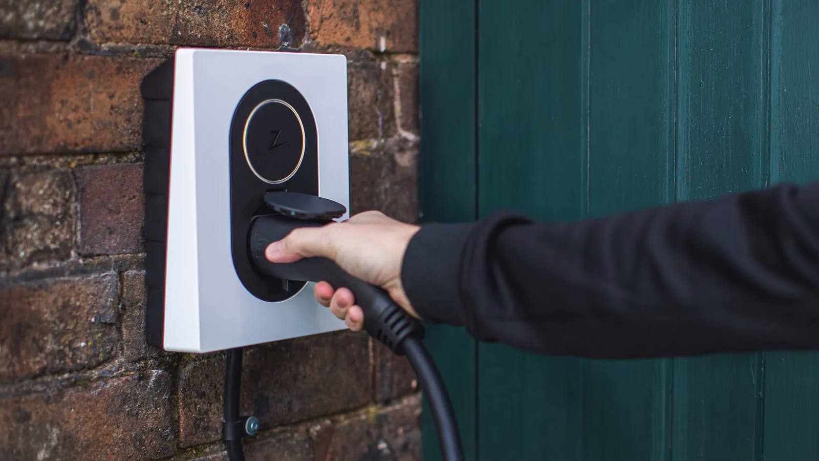 Zaptec-Wallbox mit eingestecktem Ladekabel an einer Backsteinwand – Beispielbild